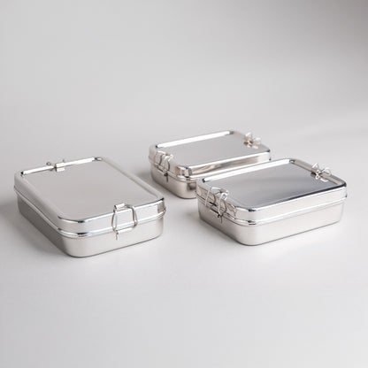 RVS lunchboxen in 3 maten langs elkaar op een witte achtergrond