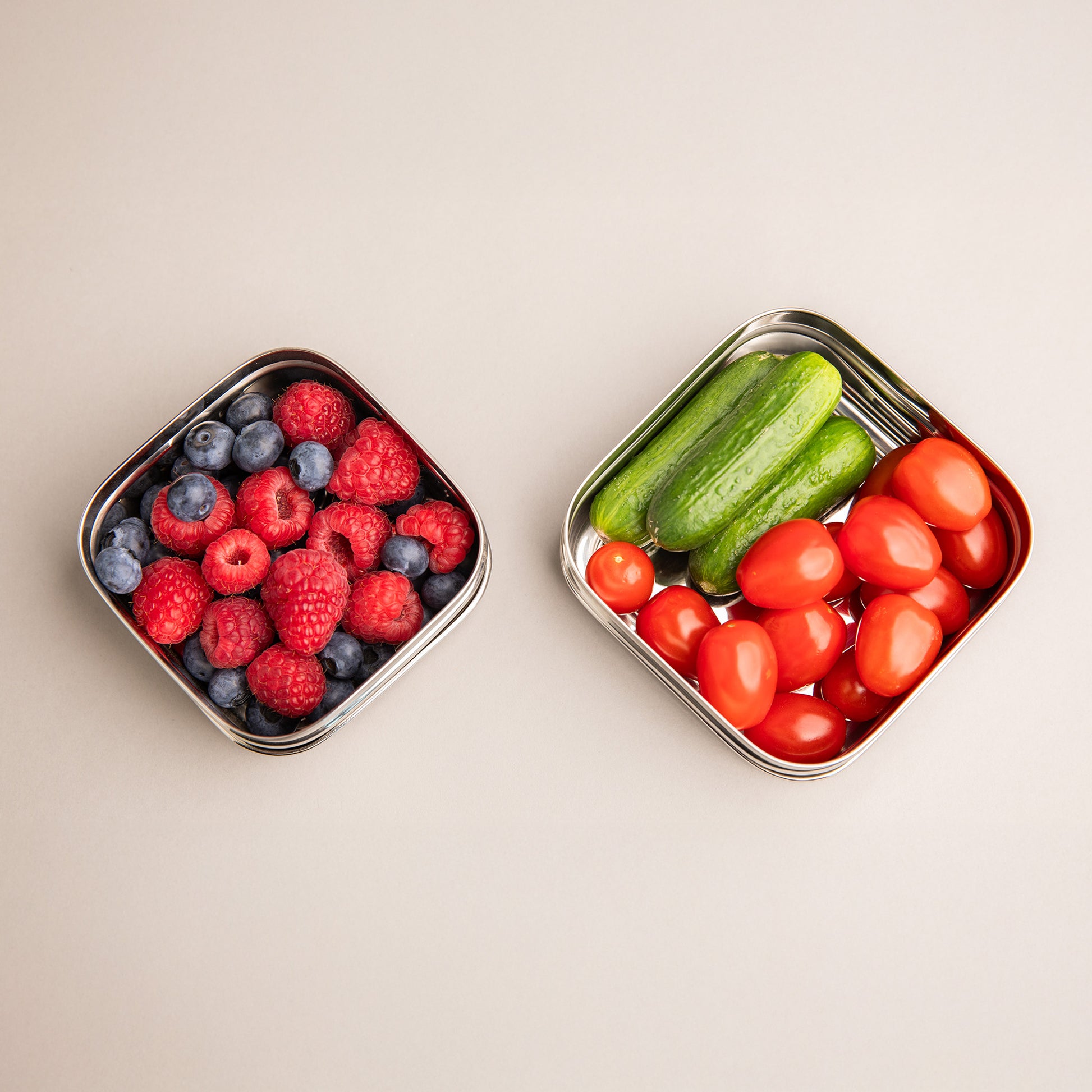 twee rvs snackboxjes gevuld met fruit en groenten